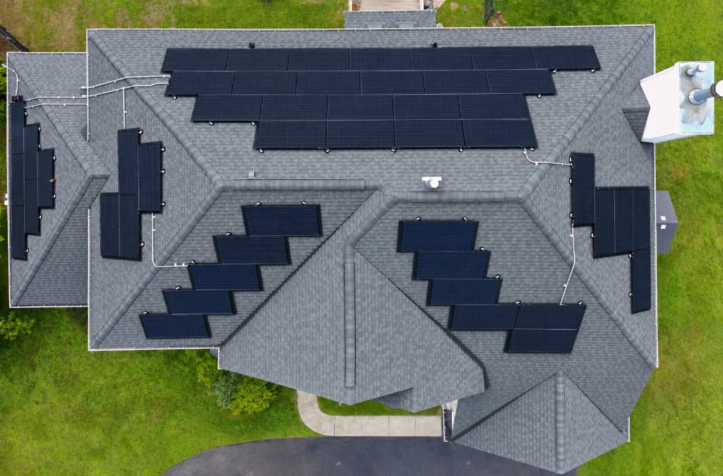 Vista aérea de um telhado residencial com arrays de painéis solares