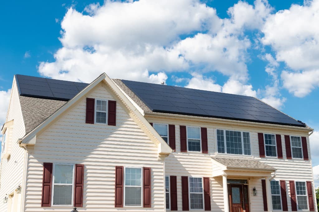 Casa residencial com painéis solares no telhado sob céu limpo